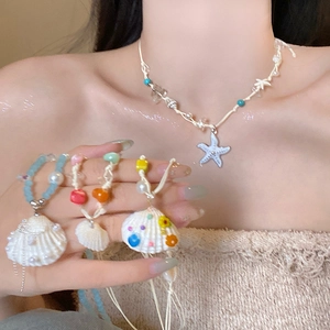 Close-up of beach jewelry set with starfish pendant and shell bracelets on model