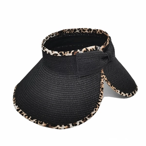 Detail of black woven sun visor with leopard print edge and decorative straw bow accent
