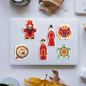 Detail of traditional Chinese folk art stickers on a white laptop with maple leaf decor