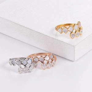 Macro shot of geometric shell rings with fine pavé crystals in gold, silver, and rose gold