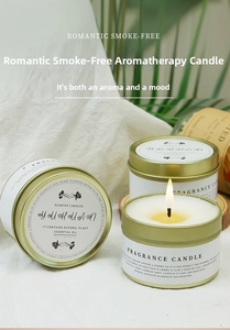 Detail of scented soy candle in white tin with gold lid set against elegant silk and leaves