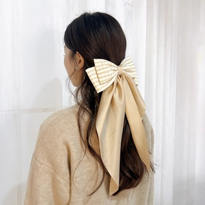 Large double-layer plaid bow hair clip with champagne streamers on a model back view