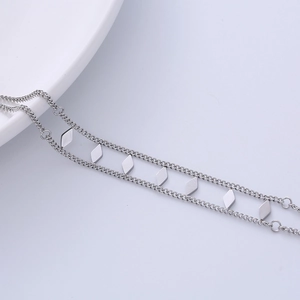 Double-layered silver stainless steel bracelet featuring polished geometric diamond charms