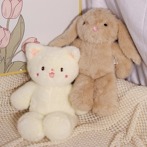 Soft plush cat and long-eared bunny toys on a cozy knitted blanket with tulip decor