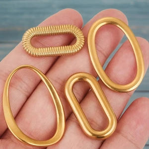 Handheld gold stainless steel oval earring connectors with textured and smooth finishes