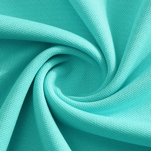 Macro view of breathable honeycomb mesh fabric texture on teal polo shirt surface