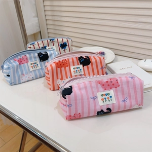 Détails de trousses en toile rayée avec motifs chats mignons et étiquette sur le bureau