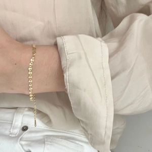 Elegant gold-plated geometric twist bracelet shown on wrist with a minimalist outfit