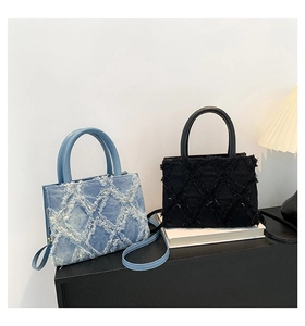Detail of blue and black quilted denim mini bags with frayed edges and leather handles