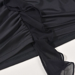 Détail du tissu plissé noir avec bords à volants en maille et coutures précises