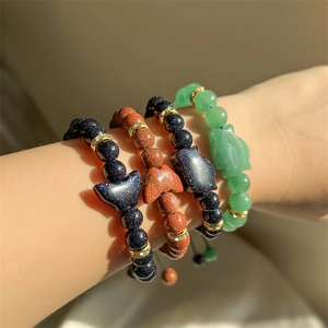 Dettaglio dei braccialetti di perline impilati con pietra del sole blu e avventurina verde