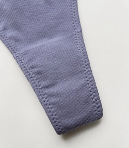 Detail shot of purple ribbed cotton thong showing elastic waistband and fine stitching