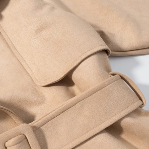 Detail view of beige faux suede jacket showing waist belt and refined fabric texture