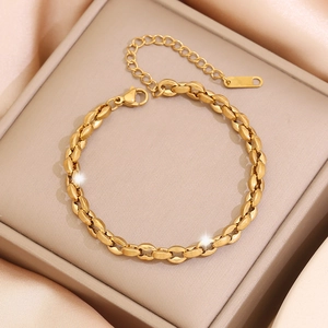 Close-up of golden link bracelet with oval-shaped buckles on beige jewelry box