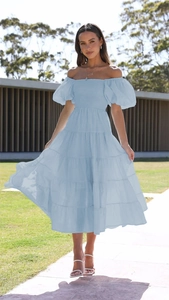 Close-up detail of light blue smocked bodice and puff sleeves on a summer dress