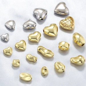 Close-up of heart and geometric metal beads in gold and silver for DIY jewelry