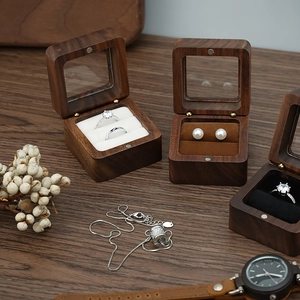 Detail of wooden jewelry box with clear window and velvet lining for rings and earrings