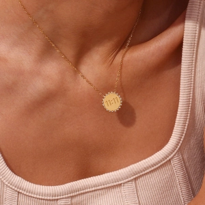 Detailed close-up of a gold 11:11 sunburst necklace worn on a model's neck