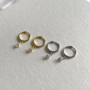 Macro detail of geometric rhomboid earrings with cubic zirconia in gold and silver finish