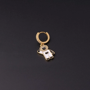 Detail of gold astronaut drop earrings featuring white enamel and sparkling zircon stones