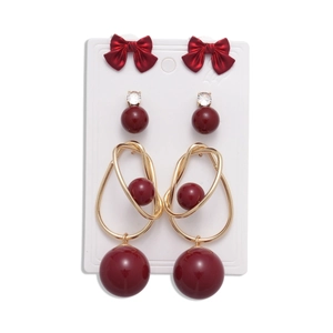 Vintage red and gold earring set with bow motifs, pearls, and crystals on a card