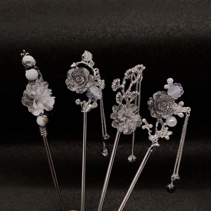 Detailed view of silver ink-wash floral hairpins with pearls and elegant tassels