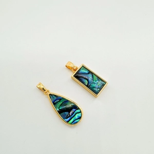 Close-up of 18k gold-plated teardrop and rectangular abalone shell pendant set