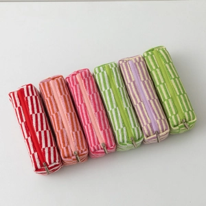 Close-up of vibrant knitted texture and metal zipper on striped checkered pouches