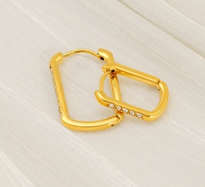 Detail of gold U-shaped hoop earrings with micro-pave cubic zirconia on soft fabric