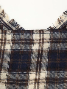Close-up of woven plaid fabric texture with frayed edges in navy and brown tones