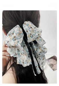 Detail of multi-layered floral chiffon bow hair claw clip with long black ribbons