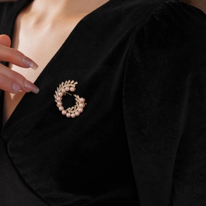 Detailed close-up of champagne pearl and zircon brooch on black velvet fabric