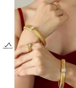 Detail of gold-plated stainless steel bracelet and ring with cubic zirconia stones