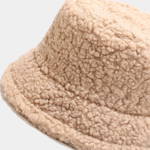 Detailed macro shot of the fluffy beige faux shearling fabric on this warm winter bucket hat