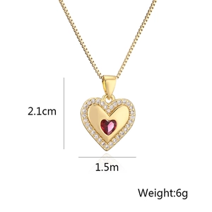 Detail shot of heart pendant necklace with red zircon center and white stone halo