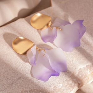 Detailed close-up of matte metal studs and gradient purple acrylic petal drop earrings