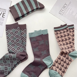 Flat lay of soft knit wool socks featuring plaid, striped and houndstooth patterns