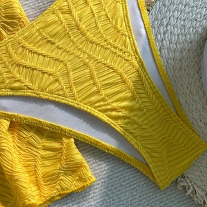 Makroaufnahme des gelben Bikinis mit Wellenstruktur und weichem weißem Innenfutter