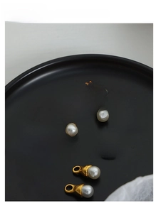Macro detail of horseshoe earrings with detachable pearls in gold and silver finish