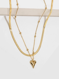 Dettaglio della collana a due strati in oro con perle tonde e pendente a cuore bombato
