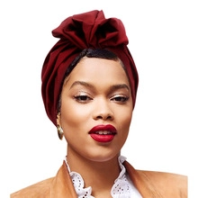 Vue détaillée du turban bordeaux à plis 3D porté par un mannequin en studio