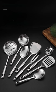 Detailed macro view of 7-piece stainless steel kitchen tool set with mirror finish