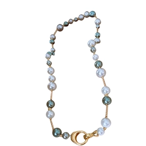 Collier de perles de style vintage français avec boule dorée et fermoir à anneau sur blanc