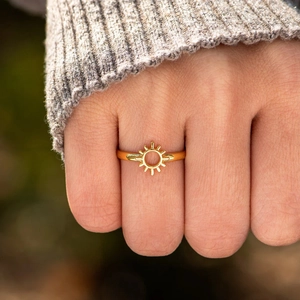 Anello sole minimalista in argento S925 dorato indossato con un maglione grigio