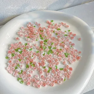 Macro view of 3D resin roses, green leaves and white pearls for nail art and DIY crafts