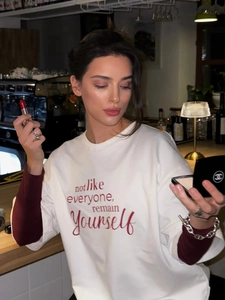 Λεπτομέρεια βαμβακερού t-shirt με γράμματα και μπορντό μανίκια σε αντίθεση