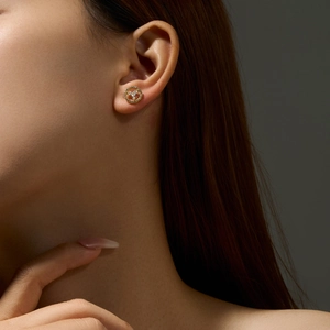 Close-up of a 925 sterling silver gold hoop earring with micro-inlaid stones on a model