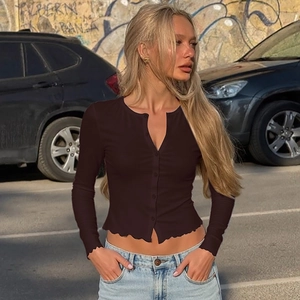 Gros plan d'un cardigan court en maille marron avec boutons et manches longues
