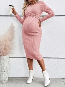 Detail of pink maternity knit dress featuring a twist waist design and long sleeves