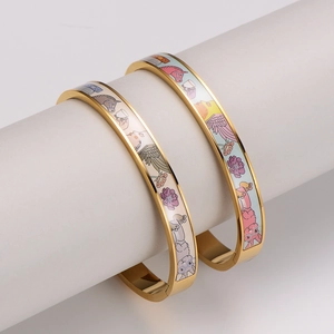 Enameled gold bangle bracelet with colorful horse and floral patterns on white stand